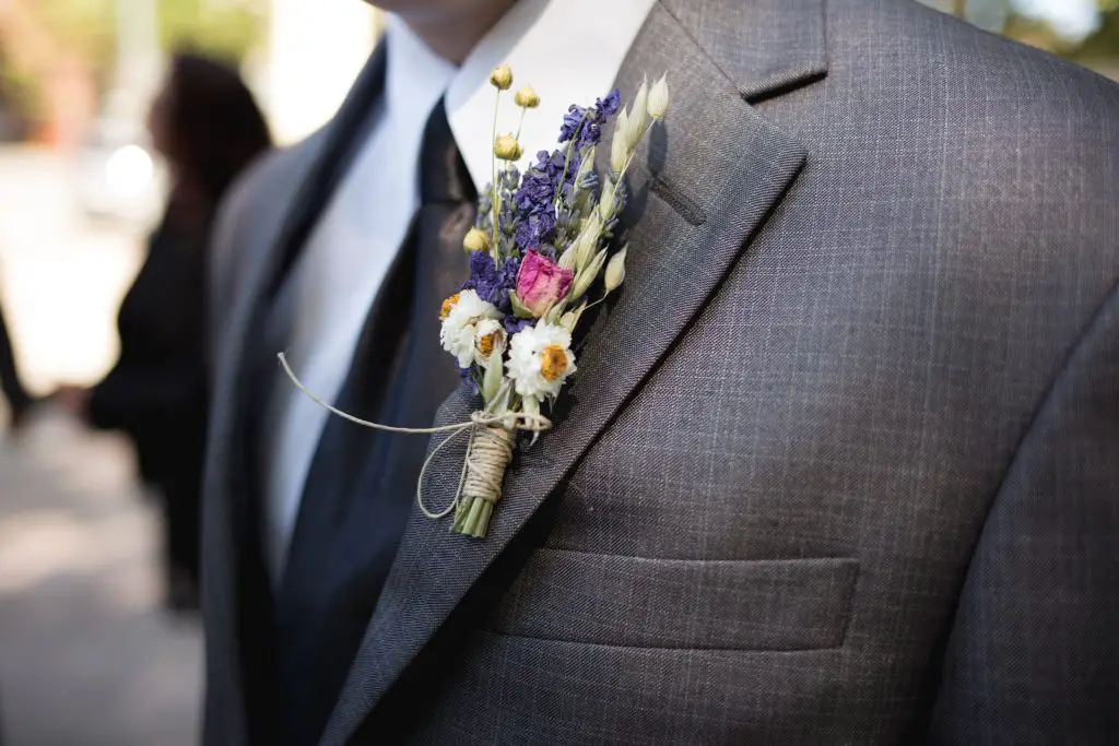 groom wears boutonniere with blazer 